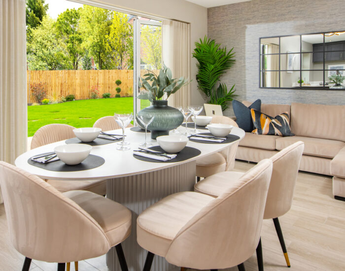 Bi-fold doors opening onto a paved patio and large turfed garden